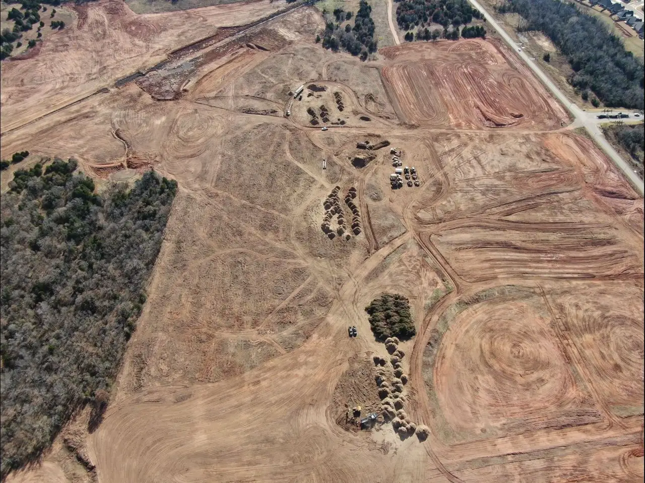Aerial view of a large Oklahoma tract cleared and windrowed, with brush piles staged for grinding