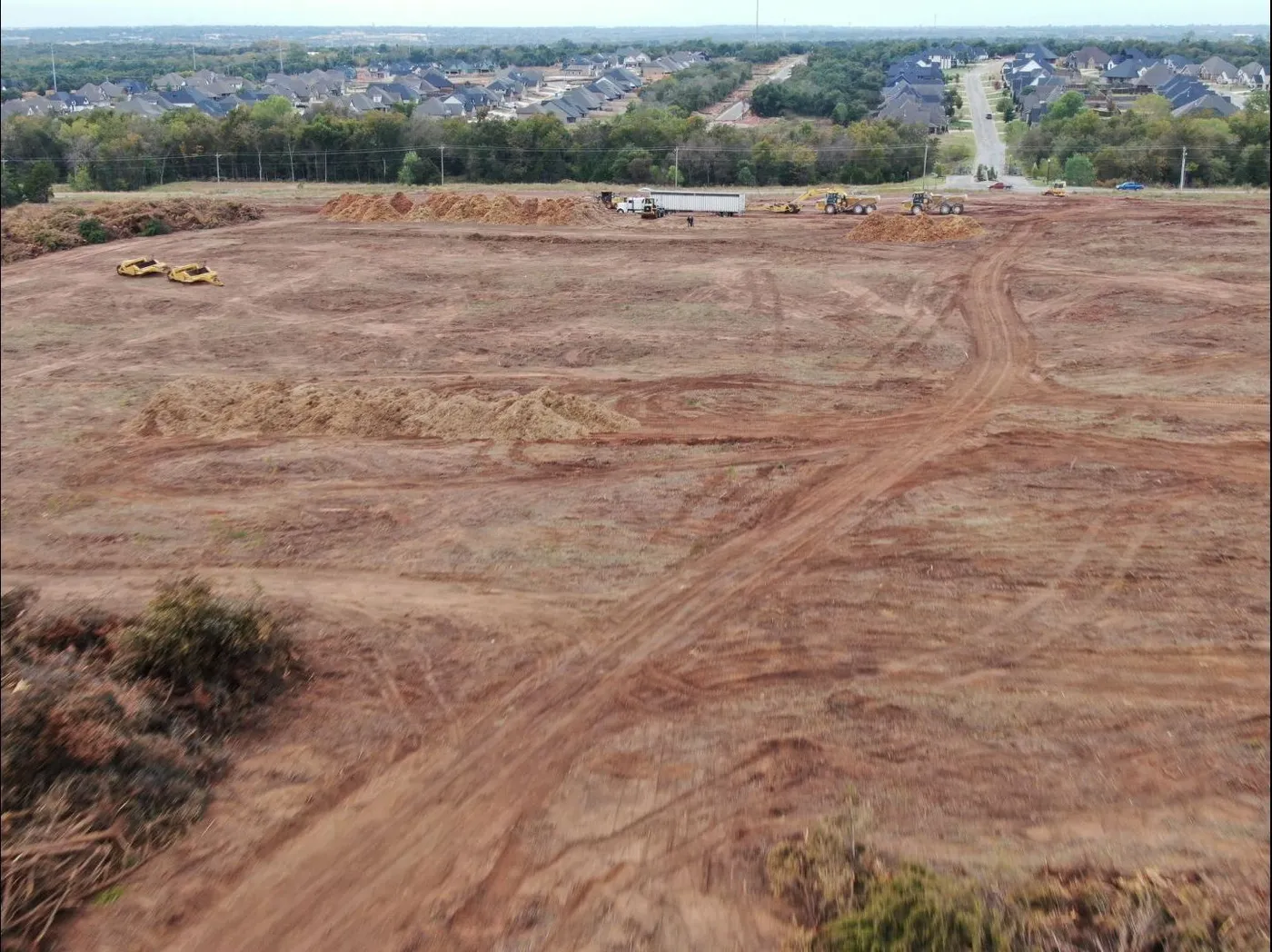 Aerial view of a large cleared and graded development tract ready to build next to an Oklahoma neighborhood
