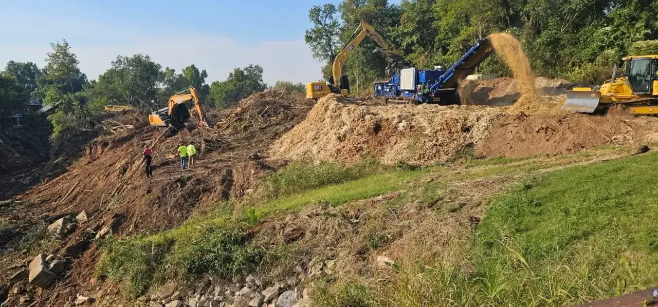 Crew clearing a wooded hillside with an excavator, dozer, and tub grinder processing brush in Oklahoma